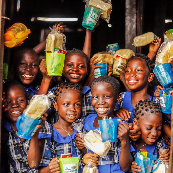Smiling children holding donated supplies