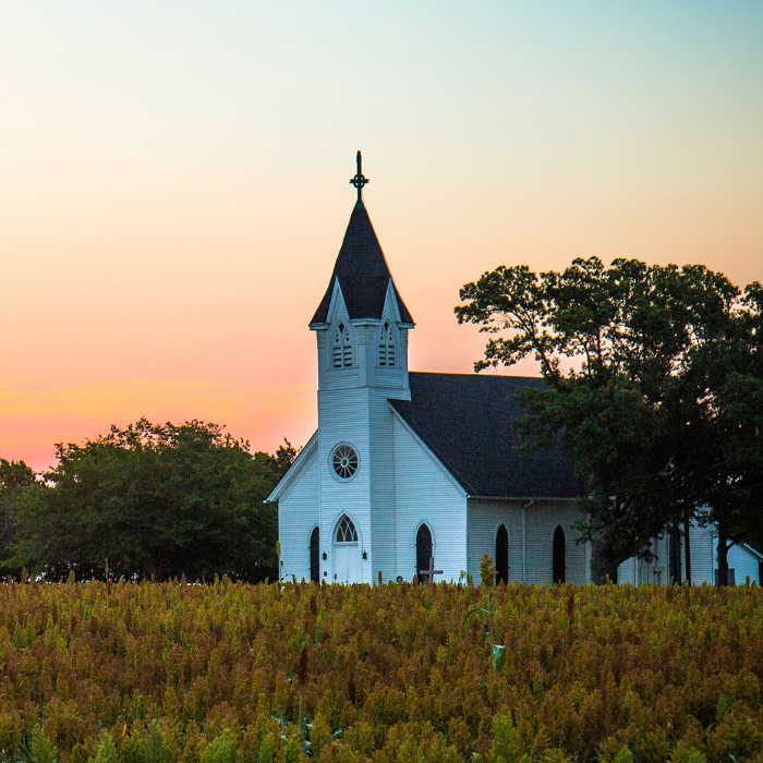 Rural church building with sunset sky backdrop